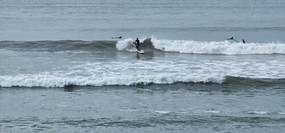 longboarder on a wave in front of the shop